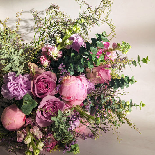 Thistle Foam Bouquet, consisting of pink peony buds, light purple carnations, pink-mauve roses, purple misty statice, lavender snapdragons and highly textural gum foliage.